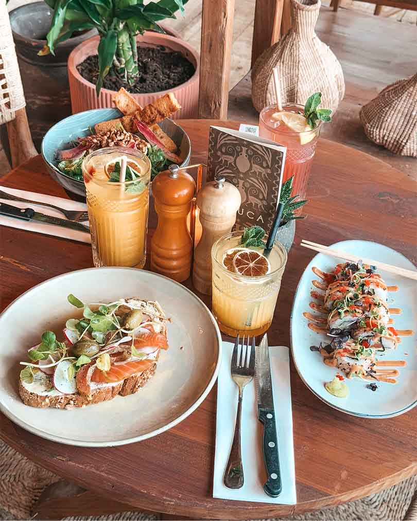 Tafel met lunchgerechten Gravad Lax sandwich en sushirol met homemade lemonades