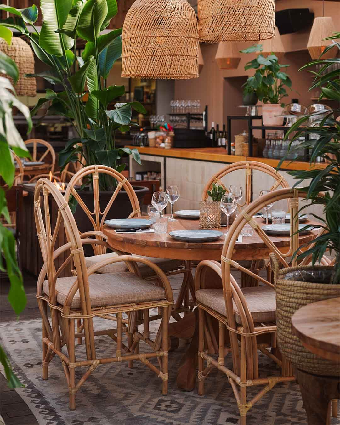 Ingedekte tafel met grote rotan stoelen bij hotspot Witsand in Noordwijk