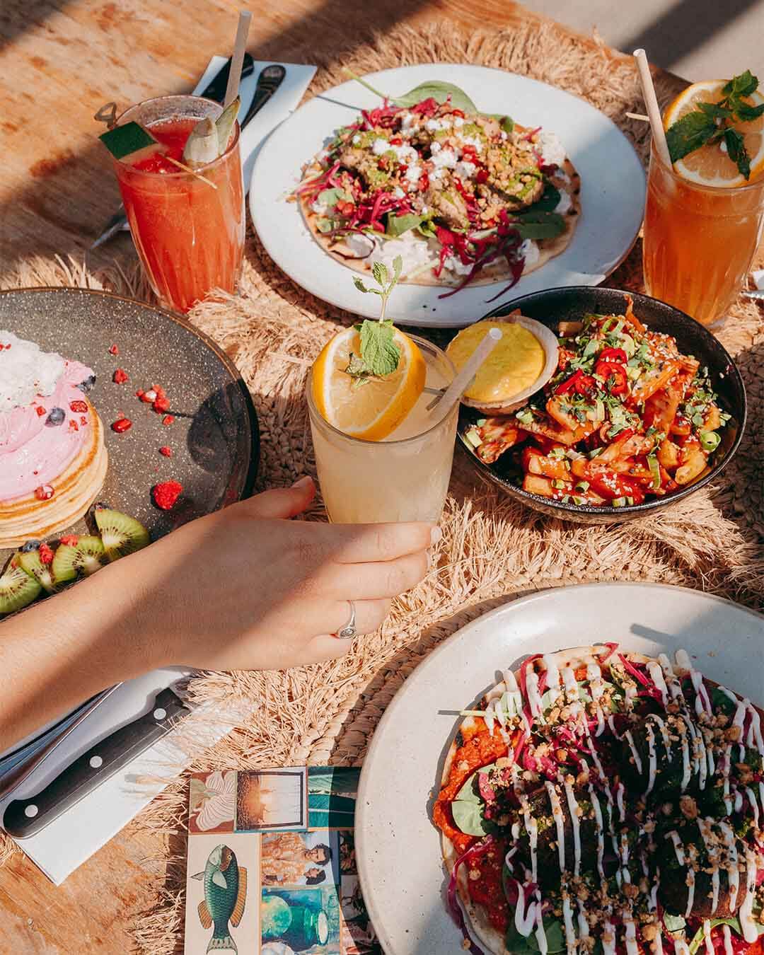 Lunch op tafel met homemade lemonades, pink pancakes, loaded fries en pita falafel