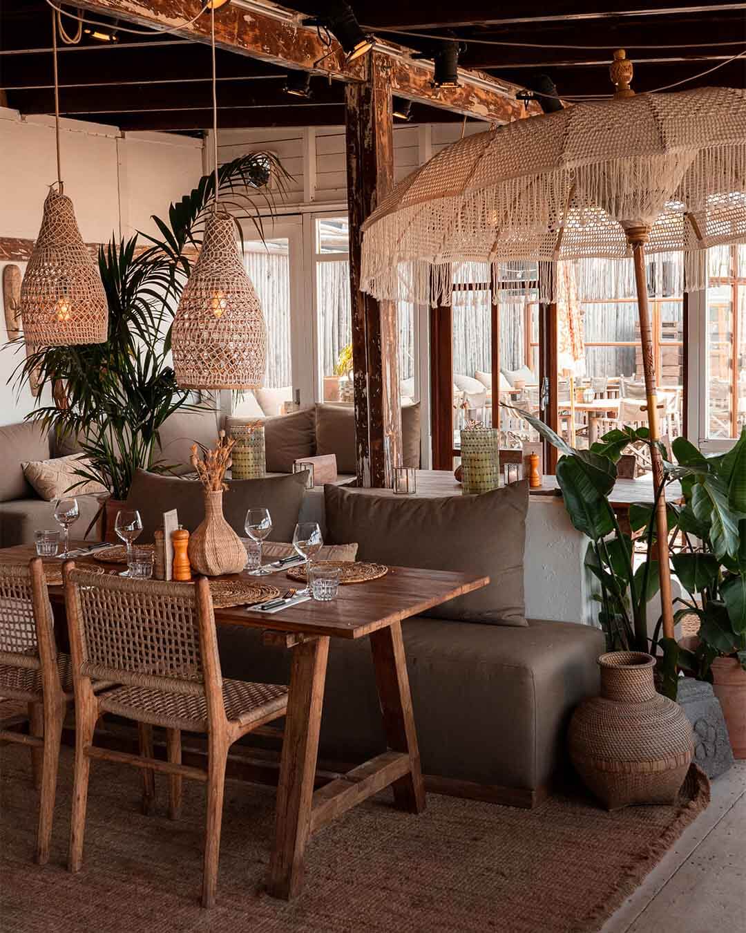 Interieurshot van ingedekte teakhouten tafel met rotan stoelen bij Kayuca