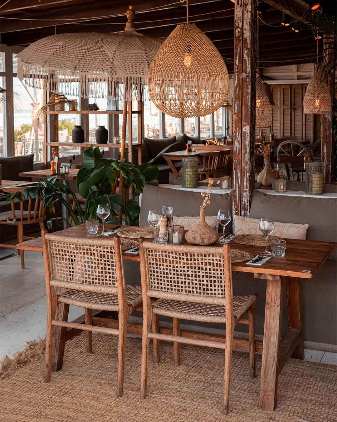 Interieurshot van ingedekte teakhouten tafel met rotan stoelen bij Kayuca