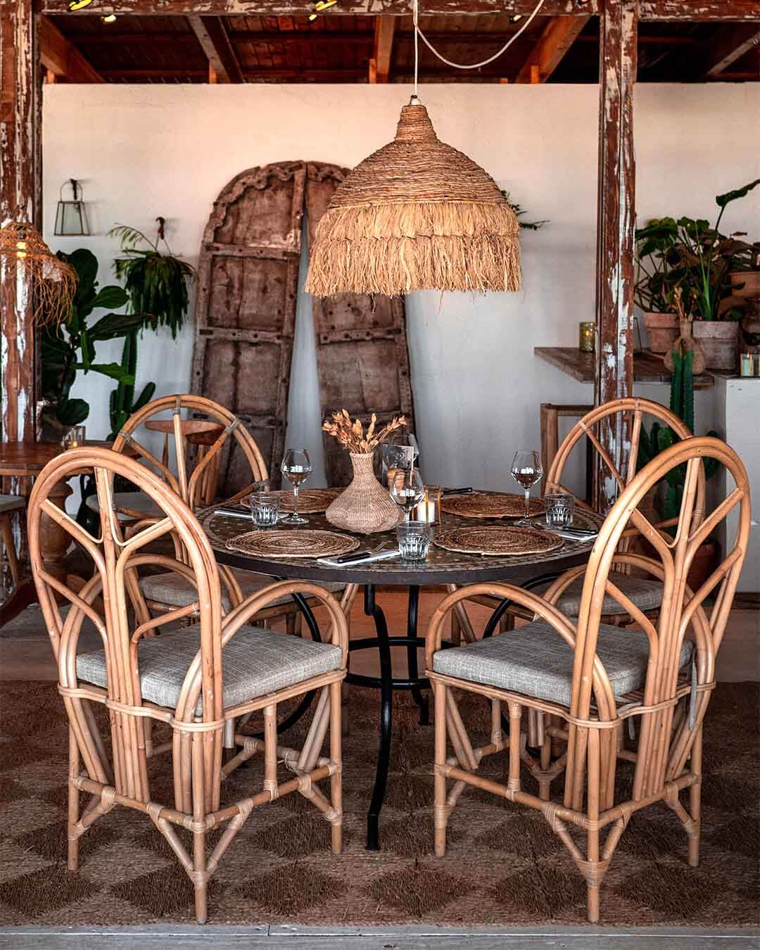 Ingedekte tafel met grote rotan stoelen bij Kayuca