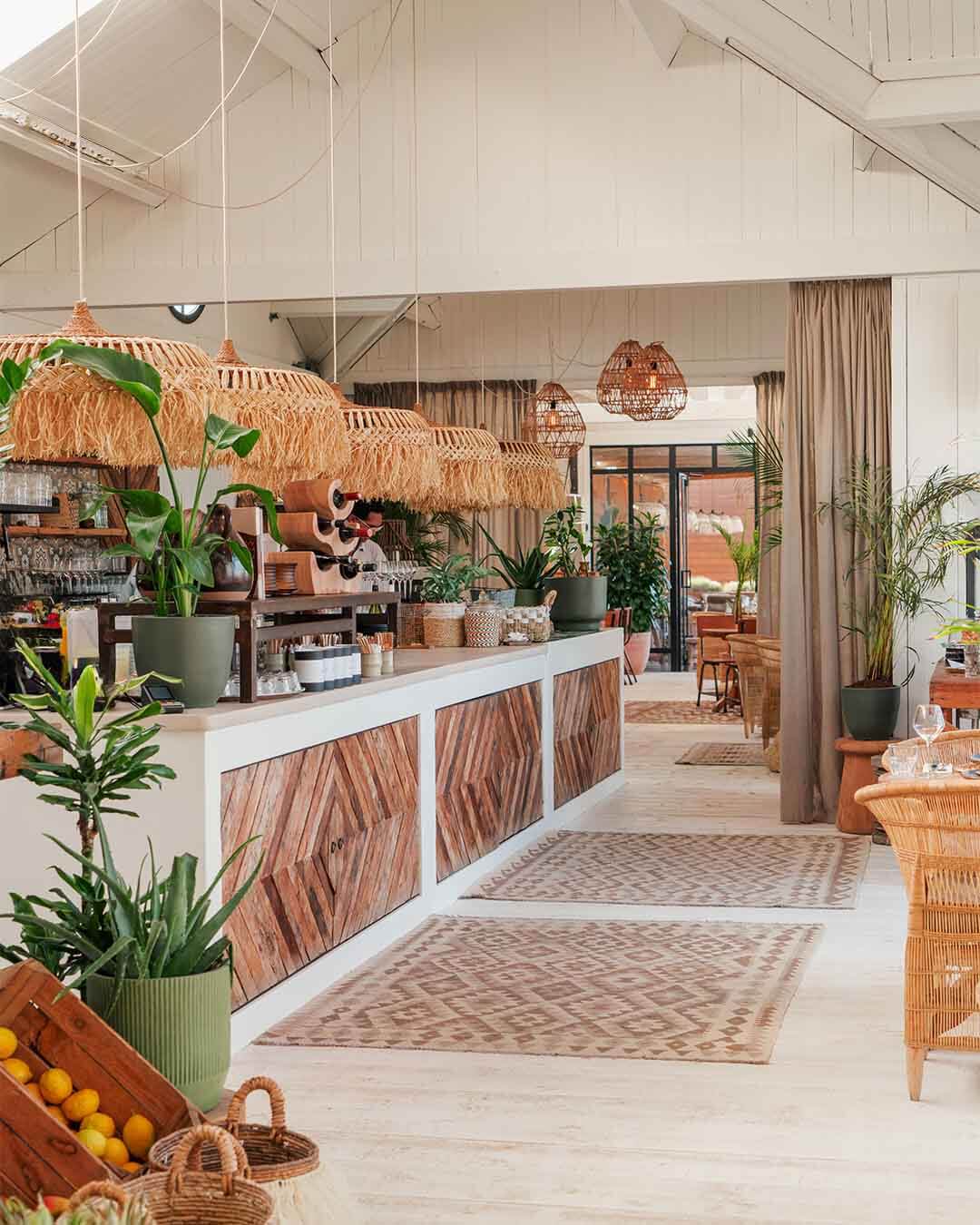 Bar met veel witte details en rotan elementen bij hotspot Tulum in Noordwijk