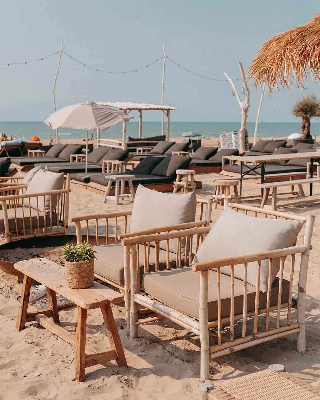 Loungeset van teakhouten stoelen in de zelfservice in het zand