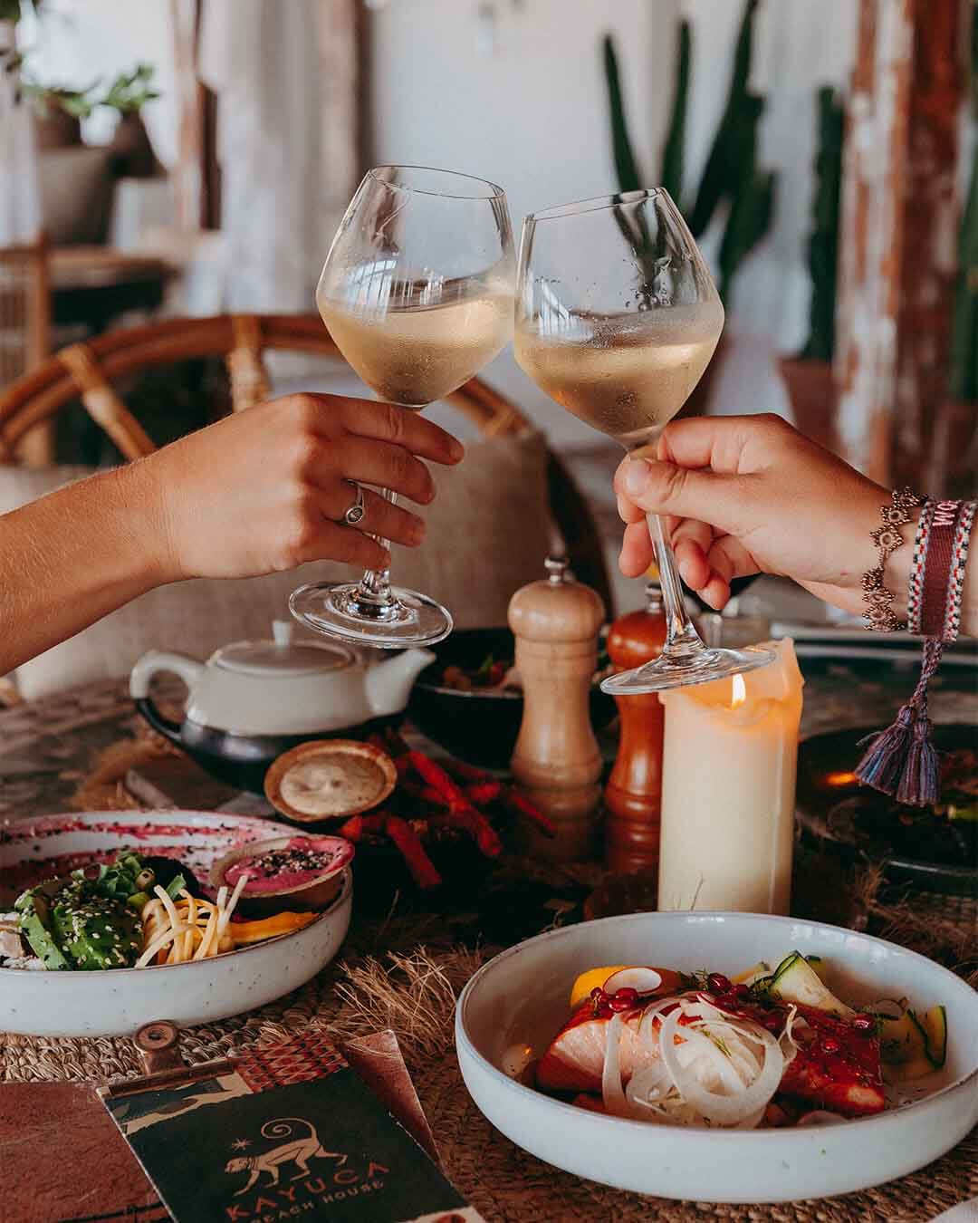 Proostmoment met wijnglazen boven een ingedekte tafel met diverse dinergerechten