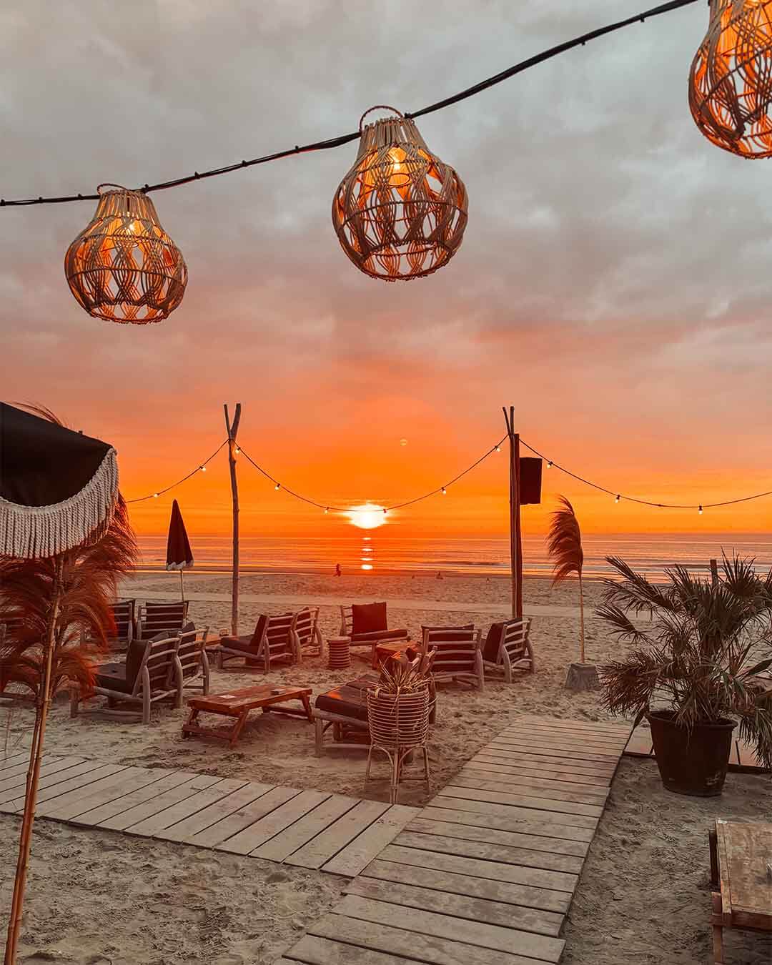 Ondergaande zon over het terras van hotspot Branding in Noordwijk