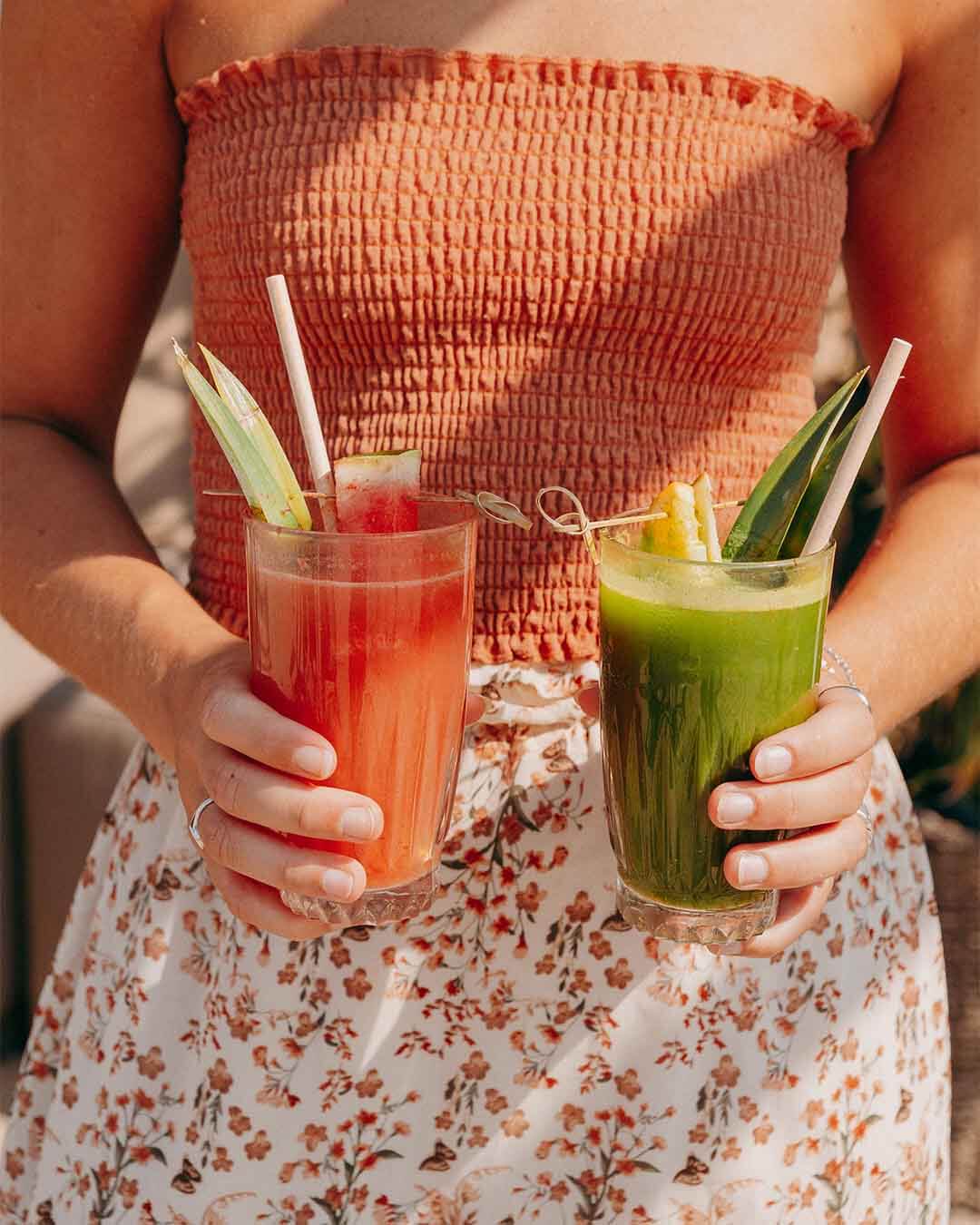 Meisje met detox juice en hippie fish juice in haar hand